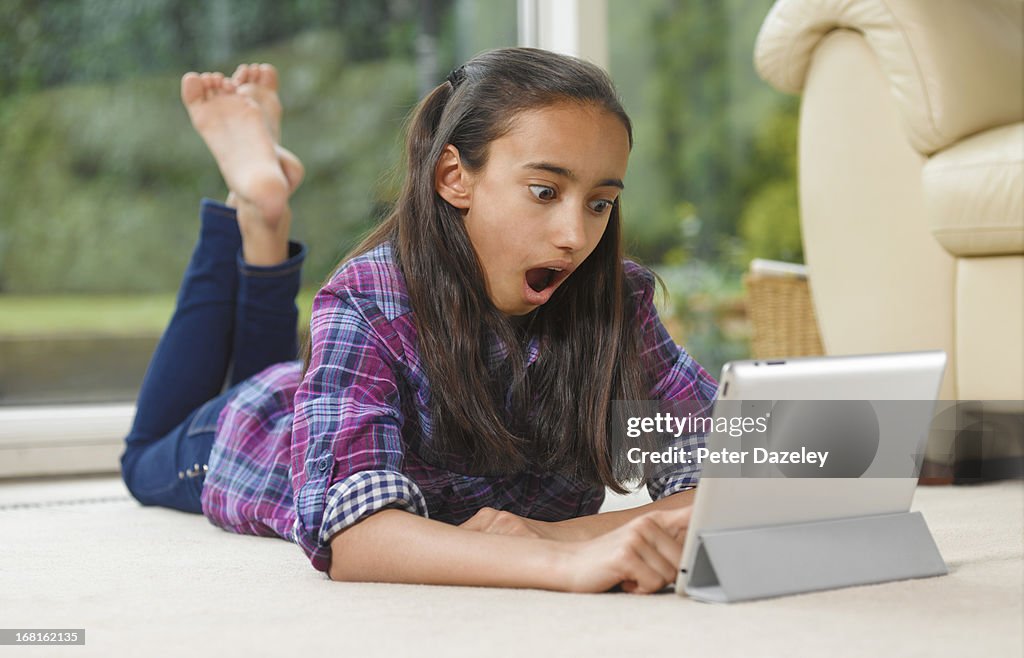 Asian/Indian girl shocked on digital tablet