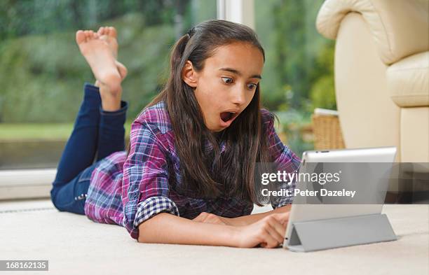 asian/indian girl shocked on digital tablet - barefoot stock pictures, royalty-free photos & images