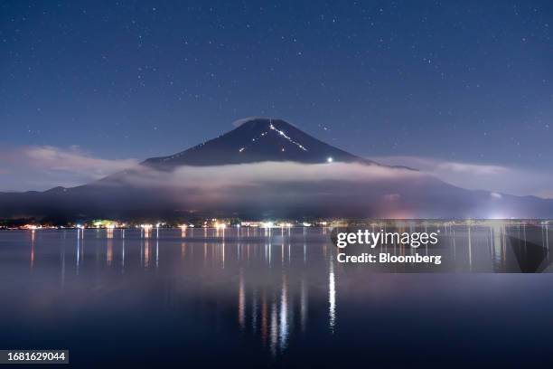 Lights carried by trekkers illuminate the trails on Mt. Fuji by Lake Yamanaka in Yamanakako, Yamanashi Prefecture, Japan on Sunday, Sept. 10, 2023....