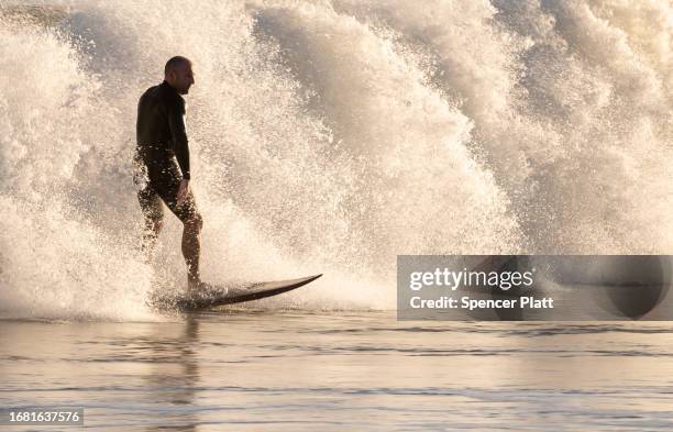 Surfers spend a day at Rockaway Beach as impact from Hurricane Lee delvers large surf and rip tides to much of the Northeast on September 14, 2023 in...