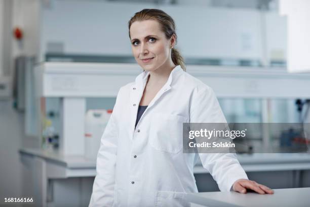 portrait of woman in laboratory - bata de laboratorio fotografías e imágenes de stock