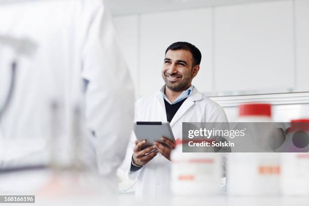 man standing in laboratory, using tablet - cure 2013 stock pictures, royalty-free photos & images