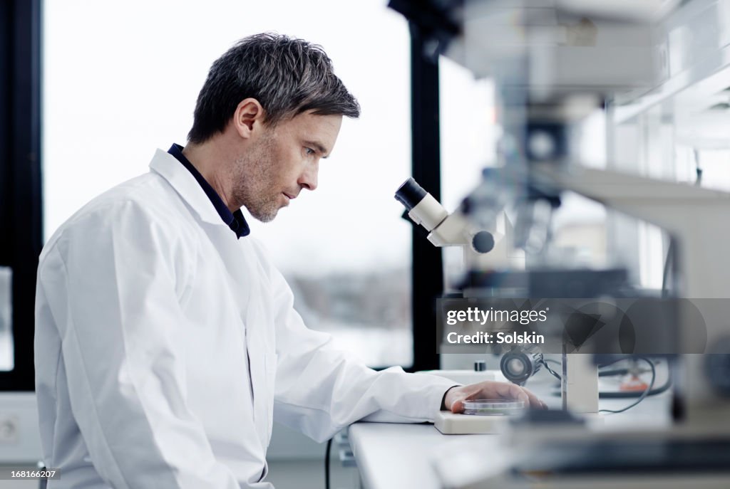 Man in laboratory using microscope