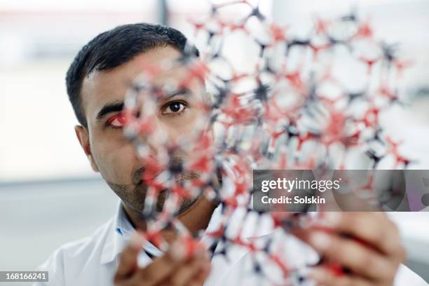 man holding chemistry molecule plastic model - indian male model stockfoto's en -beelden