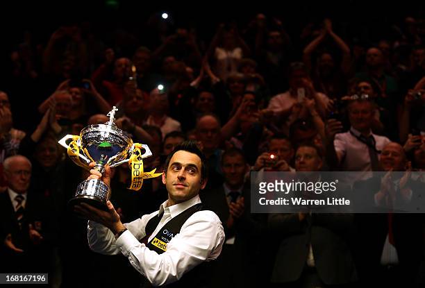 Ronnie O'Sullivan of England poses with the trophy and his son Ronnie after beating Barry Hawkins of England to win the Betfair World Snooker...