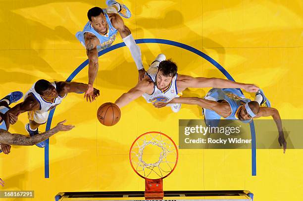 Andrew Bogut of the Golden State Warriors rebounds against Andre Iguodala and Corey Brewer of the Denver Nuggets in Game Six of the Western...