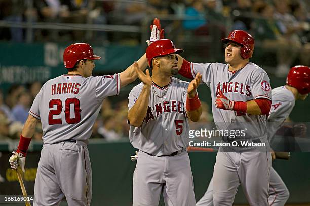Brendan Harris of the Los Angeles Angels of Anaheim congratulated Albert Pujols and Mike Trout after scoring runs against the Oakland Athletics...
