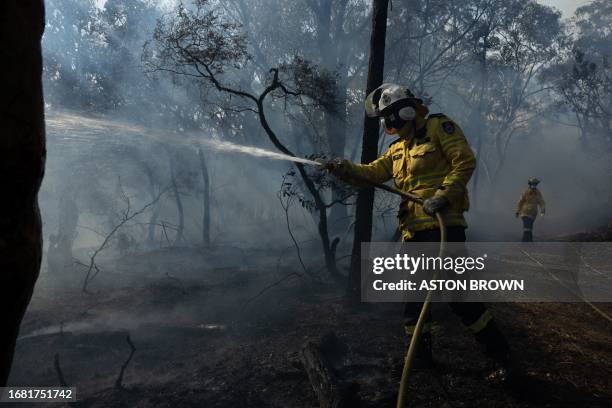 This picture taken on July 15, 2023 shows volunteer firefighters controlling a hazard reduction burn in north Sydney. Australian firefighters are...