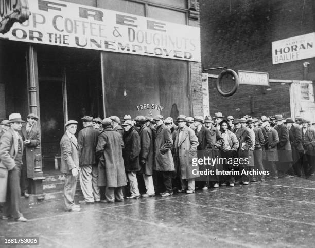 During the Great Depression, view of a line of men standing outside a soup kitchen opened by gangster Al Capone in Chicago, Illinois, February 1931....