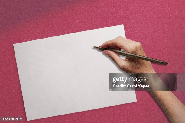 female hand ready to write in a blank paper - hand written letter ストックフォトと画像