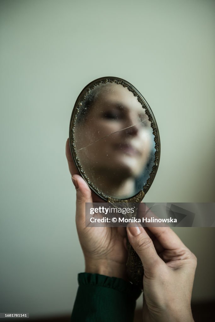 Woman's face reflection in a hand-held mirror