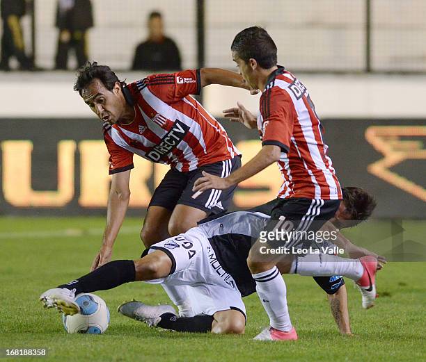 Marcos Gelabert and Maximiliano Nuñez of Estudiantes de La Plata struggles for the ball with Hernan Grana of All Boys during a match between...