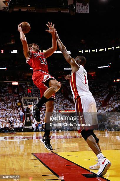 Joakim Noah of the Chicago Bulls shoots over Chris Bosh of the Miami Heat during Game One of the Eastern Conference Semifinals of the 2013 NBA...