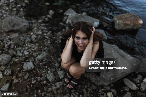 directly above view of distraught woman crying while sitting by river - hopelessness ストックフォトと画像