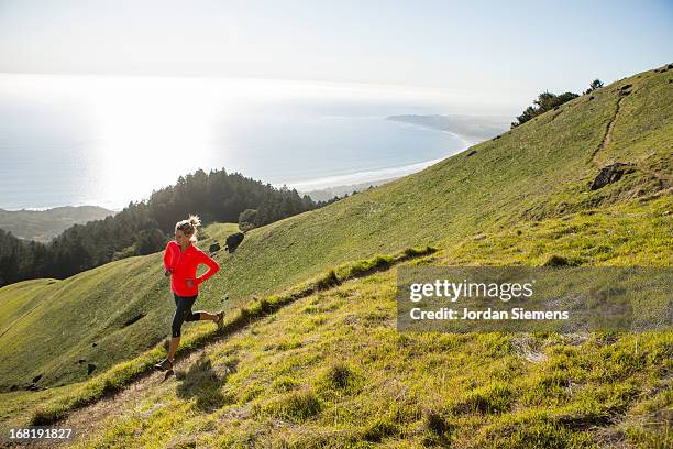 trail running above the ocean. - trailrunning stock-fotos und bilder