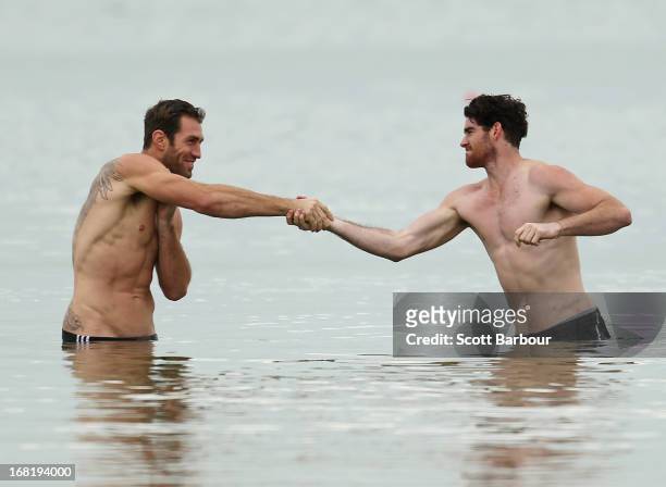 Travis Cloke and Tyson Goldsack of the Magpies shake hands as they wade in the water during a Collingwood Magpies AFL recovery session at St Kilda...