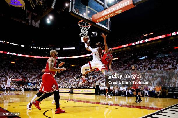 Dwyane Wade of the Miami Heat shoots past Joakim Noah and Carlos Boozer of the Chicago Bulls during Game One of the Eastern Conference Semifinals of...