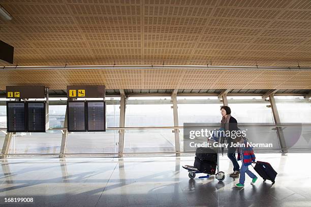 mother with young son and luggage at airport - malaga walking stockfoto's en -beelden