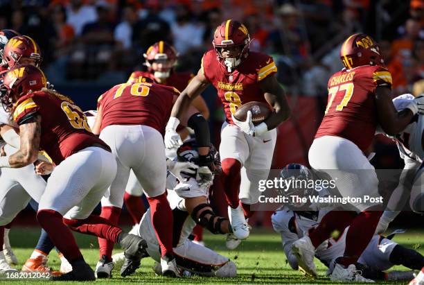 Washington Commanders running back Brian Robinson Jr. Finds a hole and makes a long gain during the Washington Commanders defeat of the Denver...