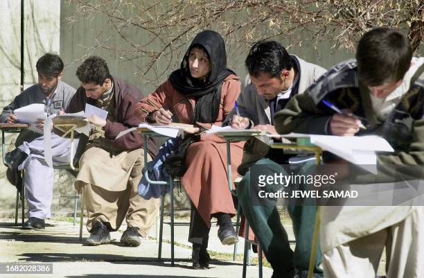 An Afghan woman sits an exam along with male students at Kabul University, 20 February 2002. During the fundamentalist Taliban rule, women were...