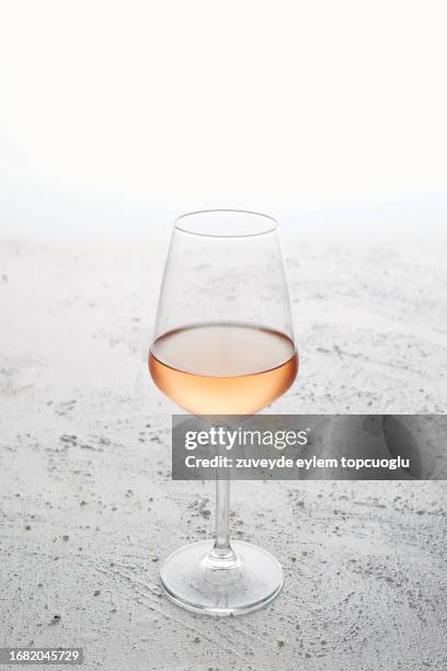 a glass of rose wine at white background with copy space - vino rosado fotografías e imágenes de stock