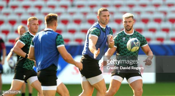 George North passes the ball watched by Johnny Williams during the Wales training session ahead of their Rugby World Cup France 2023 match against...