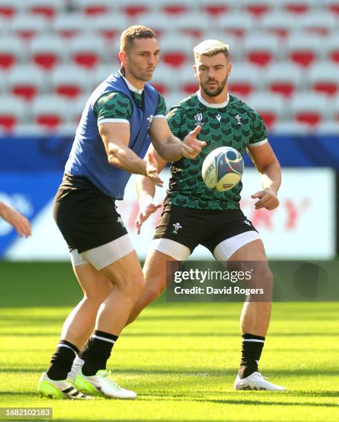 George North passes the ball watched by Johnny Williams during the Wales training session ahead of their Rugby World Cup France 2023 match against...