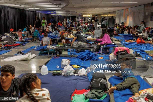 Recently arrived migrants in a makeshift shelter operated by the city of Chicago at O'Hare International Airport on Aug. 31, 2023.
