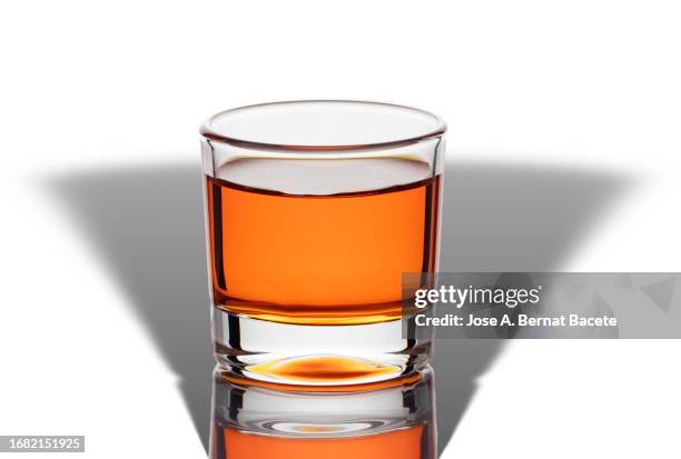 shot glass with liquor on a white background with a little shadow. - schottischer whisky stock-fotos und bilder