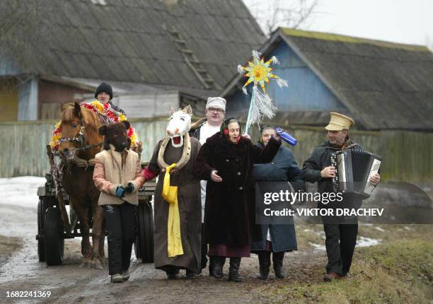 Masked local people with a horse carriage sing Christmas carols on a street of the town of Lepel, some 180 km from the capital Minsk, 07 January...