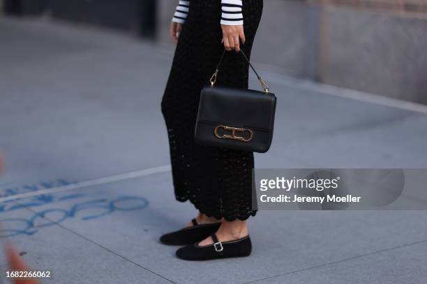 Charlotte Groeneveld is seen wearing a black/white striped long-sleeved top; a black, perforated, high-waisted cut maxi skirt; a black leather bag...