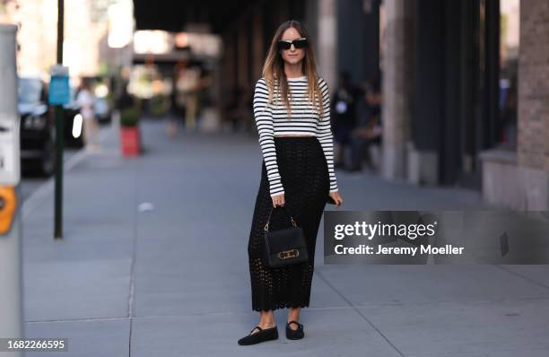 Charlotte Groeneveld is seen wearing black sunglasses; a black/white striped long-sleeved top; a black, perforated, high-waisted cut maxi skirt; a...