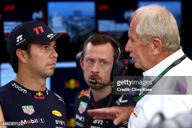 Sergio Perez of Mexico and Oracle Red Bull Racing talks with Red Bull Racing Team Consultant Dr Helmut Marko in the garage during practice ahead of...