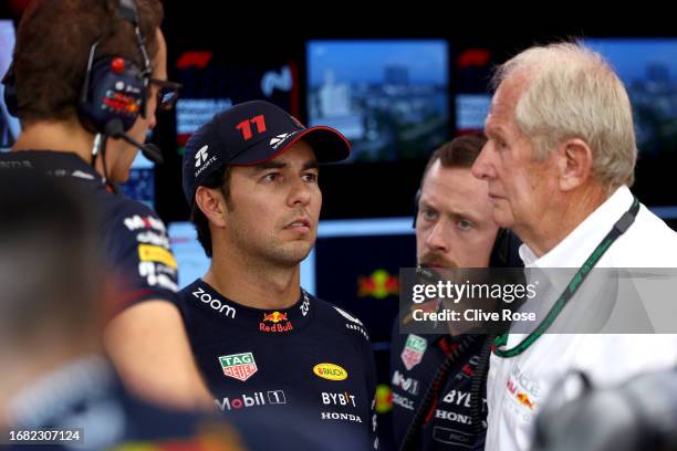 Sergio Perez of Mexico and Oracle Red Bull Racing talks with Red Bull Racing Team Consultant Dr Helmut Marko in the garage during practice ahead of...
