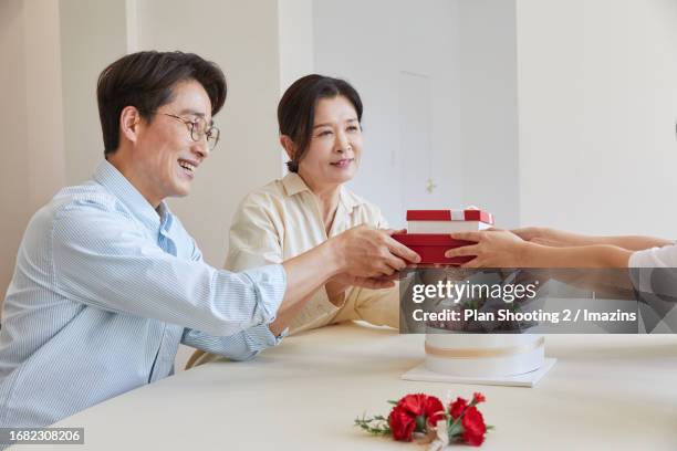 family, family month, parent's day, gratitude, smile, gift, handing over - man holding out flowers stock pictures, royalty-free photos & images