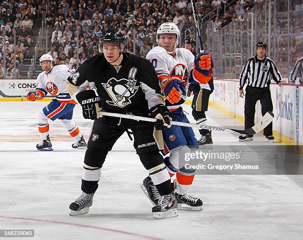 Chris Kunitz of the Pittsburgh Penguins battles for position against Keith Aucoin of the New York Islanders in Game One of the Eastern Conference...