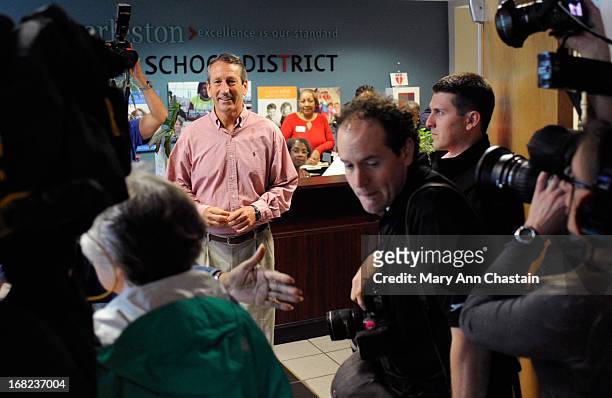 Former South Carolina Gov. Mark Sanford is surrounded by media as he waits to enter the polling place to cast his vote in the special election runoff...