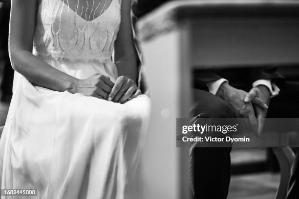 monochrome picture of the newlyweds hands in the church - christian stock pictures, royalty-free photos & images