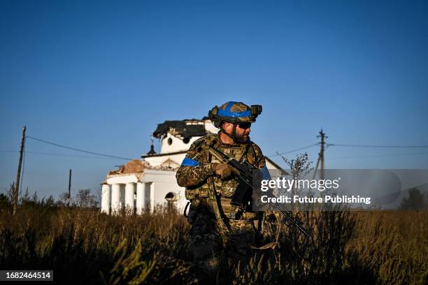 Serviceman of a reconnaissance platoon of the 3rd Separate Assault Brigade who goes by the call sign 'Akela' holds a rifle.