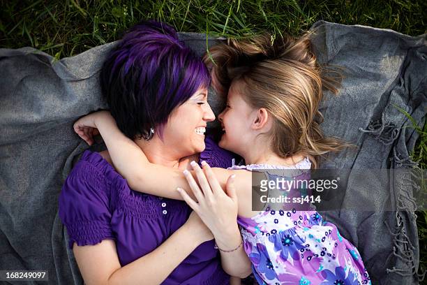 elegante disposición de la madre con hija riendo en pasto - purple hair fotografías e imágenes de stock