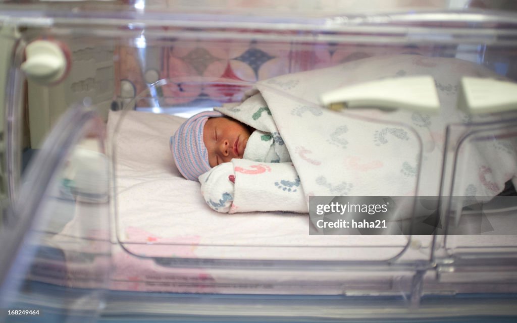 Premature biracial baby in hospital incubator