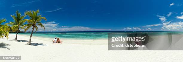 young couple relaxing on beach - panoramic view stock pictures, royalty-free photos & images
