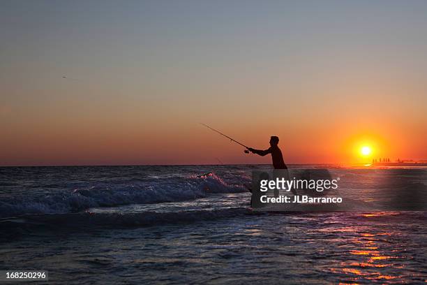 father & son surf fishing at sunset - surf casting stock pictures, royalty-free photos & images