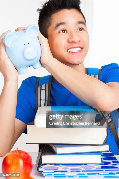 hombre sonriente estudiante agitación alcancía - shaking fotografías e imágenes de stock