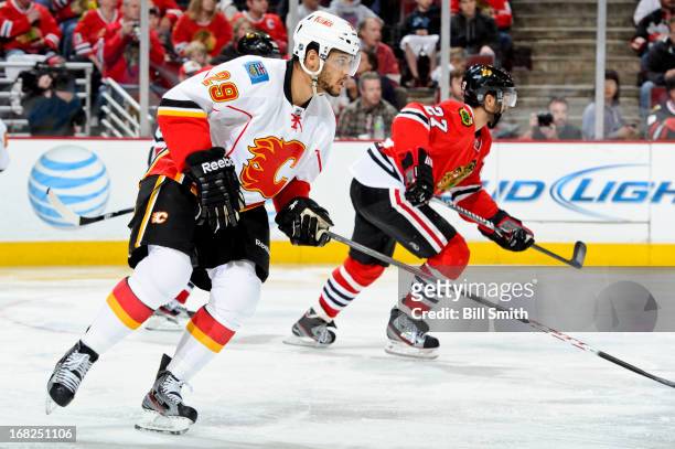 Akim Aliu of the Calgary Flames and Johnny Oduya of the Chicago Blackhawks skate up the ice during the NHL game on April 26, 2013 at the United...