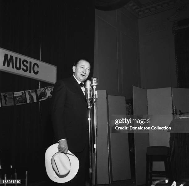 Entertainer Tex Ritter demonstrates the Nashville sound for the Country Music Association during a luncheon and recording session for the promotional...