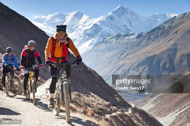 female mountainbike leader on annapurna circuit, nepal - mountain biking stock pictures, royalty-free photos & images