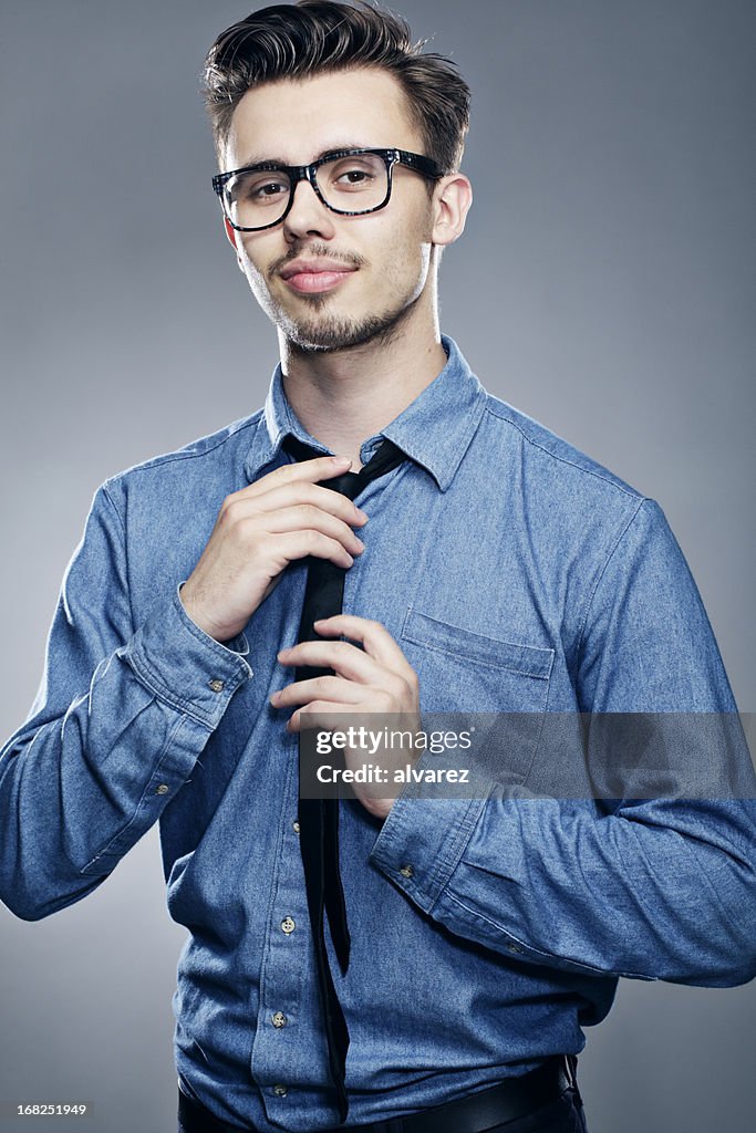 Young man doing his tie