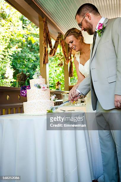 bride and groom cutting wedding cake - wedding cake cutting stockfoto's en -beelden