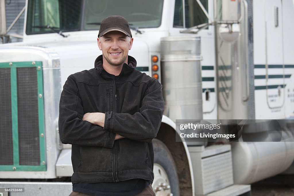 A truck driver posing in front of his truck